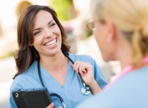 A smiling female doctor talking to a patient outdoors.