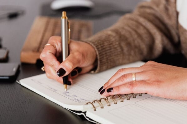 A woman writing on a notebook