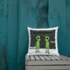 A pillow with an image of two green aliens.