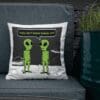 A pillow with two green aliens on it