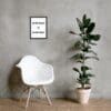 A white chair and plant in front of a wall.