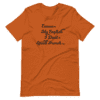 An orange t-shirt with a quote written in black.