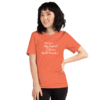 A woman standing in front of an orange background.