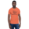 A man wearing an orange t-shirt with the words " excuse my english i think it's spelled french ".