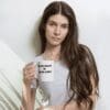 A woman holding a coffee mug with the words " be yourself ".