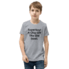 A boy wearing jeans and a t-shirt with the words " superboy ! a chip off the old steel ".
