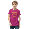 A young boy wearing a pink shirt with the words " superboy !" on it.