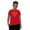 A boy wearing a red shirt with the words " superboy ! a chip off the old steel ".