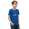 A boy wearing blue shirt and jeans with text on it.