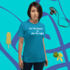 unisex-staple-t-shirt-aqua-front-628f1d08944e5 A woman standing in front of a blue wall.