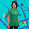 unisex-staple-t-shirt-kelly-front-628f1d088ef1 A woman standing in front of a green wall.