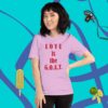 A woman standing in front of a wall with a t-shirt.