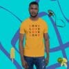 A man wearing a yellow shirt with the word love written in multiple languages.