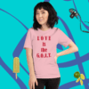 A woman standing in front of a pink wall.