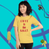 A woman standing in front of a wall with a t-shirt.