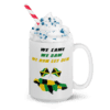 A mug with whipped cream and some type of candy.