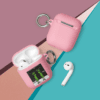 A pink case with a key chain and two other items.