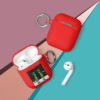 A red case next to an apple airpod holder.