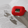 A red device is on top of an open book.