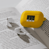 A yellow device is on top of an open book.