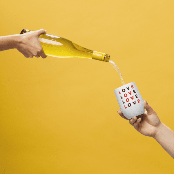 A person pouring white wine on a white wine tumbler