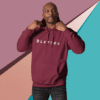 A man in a maroon hoodie is posing for the camera.