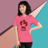 Young woman wearing a pink graphic t-shirt with abstract design, posing against a colorful geometric background.