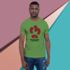 Man wearing a green t-shirt with a red graphic standing against a colorful geometric background.
