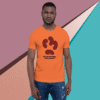 Man wearing an orange T-shirt with a puzzle piece design.