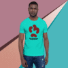 Man wearing a turquoise graphic T-shirt and blue jeans against a colorful background.