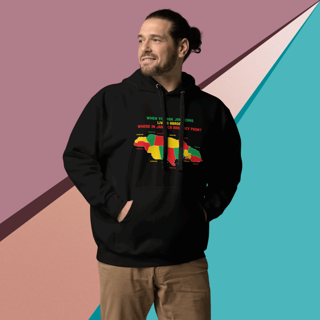 Man smiling, wearing a black hoodie with colorful text, standing against a geometric pastel background.