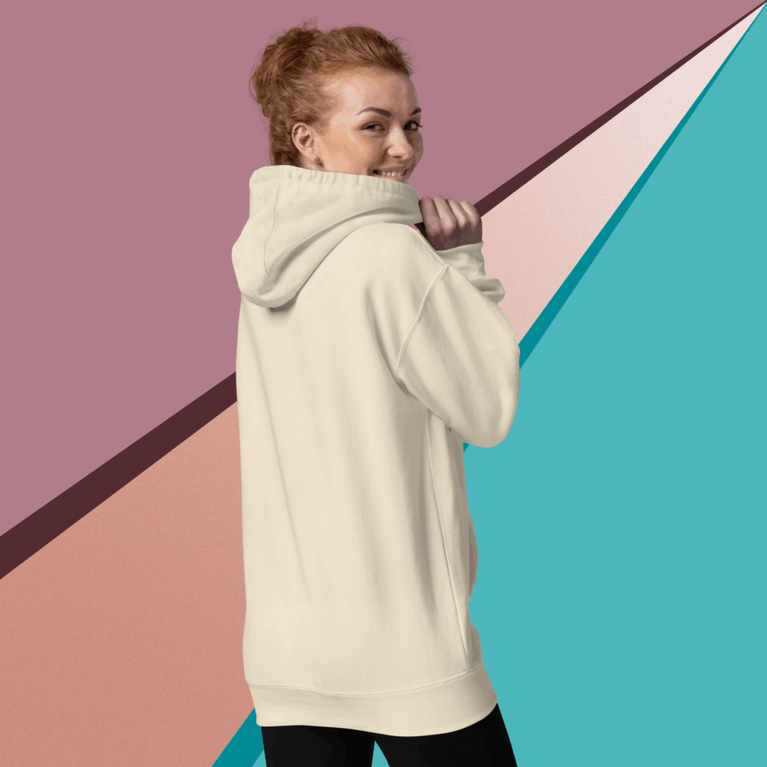 cotton-heritage-m2580-i-unisex-premium-pullover-hoodie-bone-back-68f046de0b5c0 Young woman in a cream hoodie against a colorful geometric background.