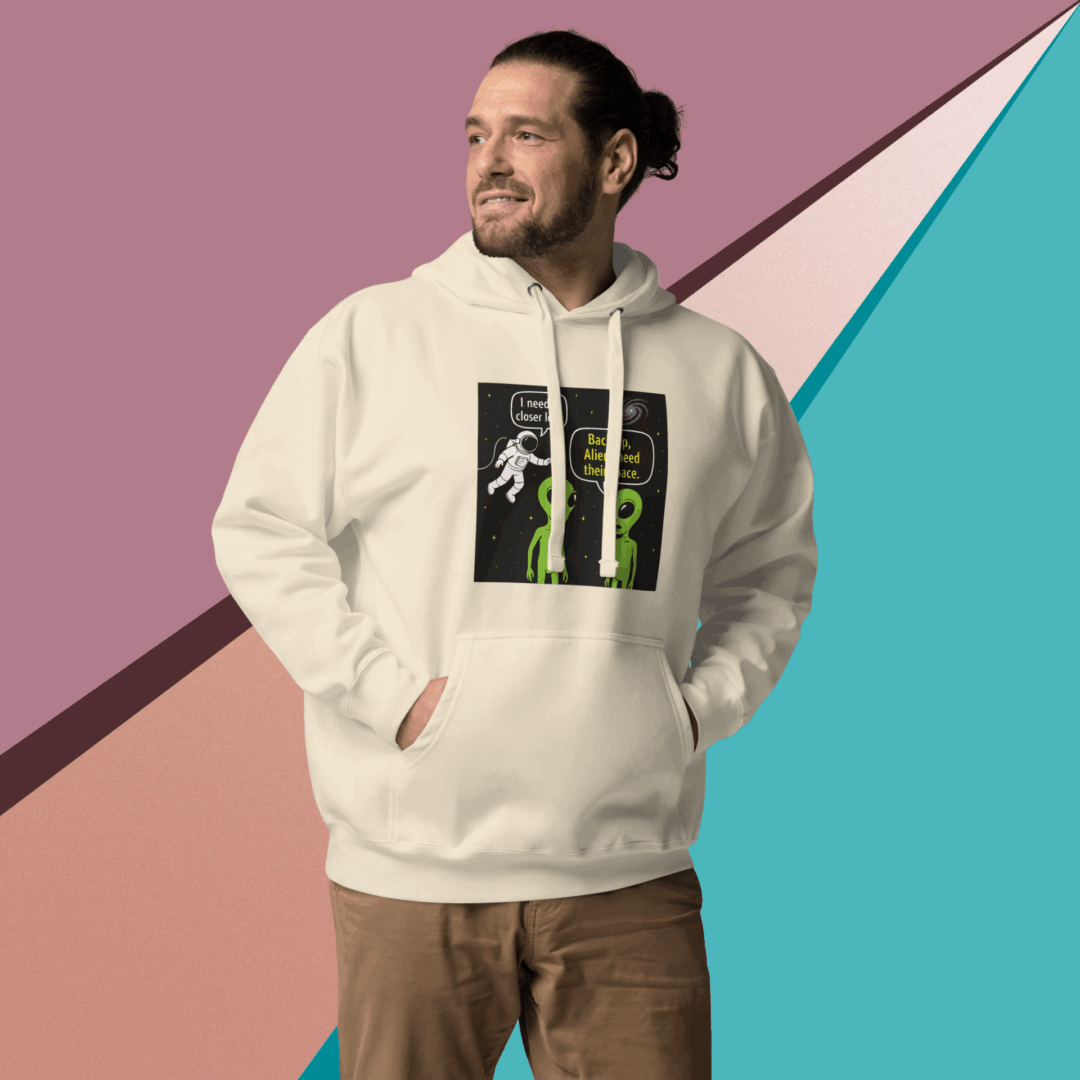 Man in beige hoodie with graphic print posing against a colorful geometric background.
