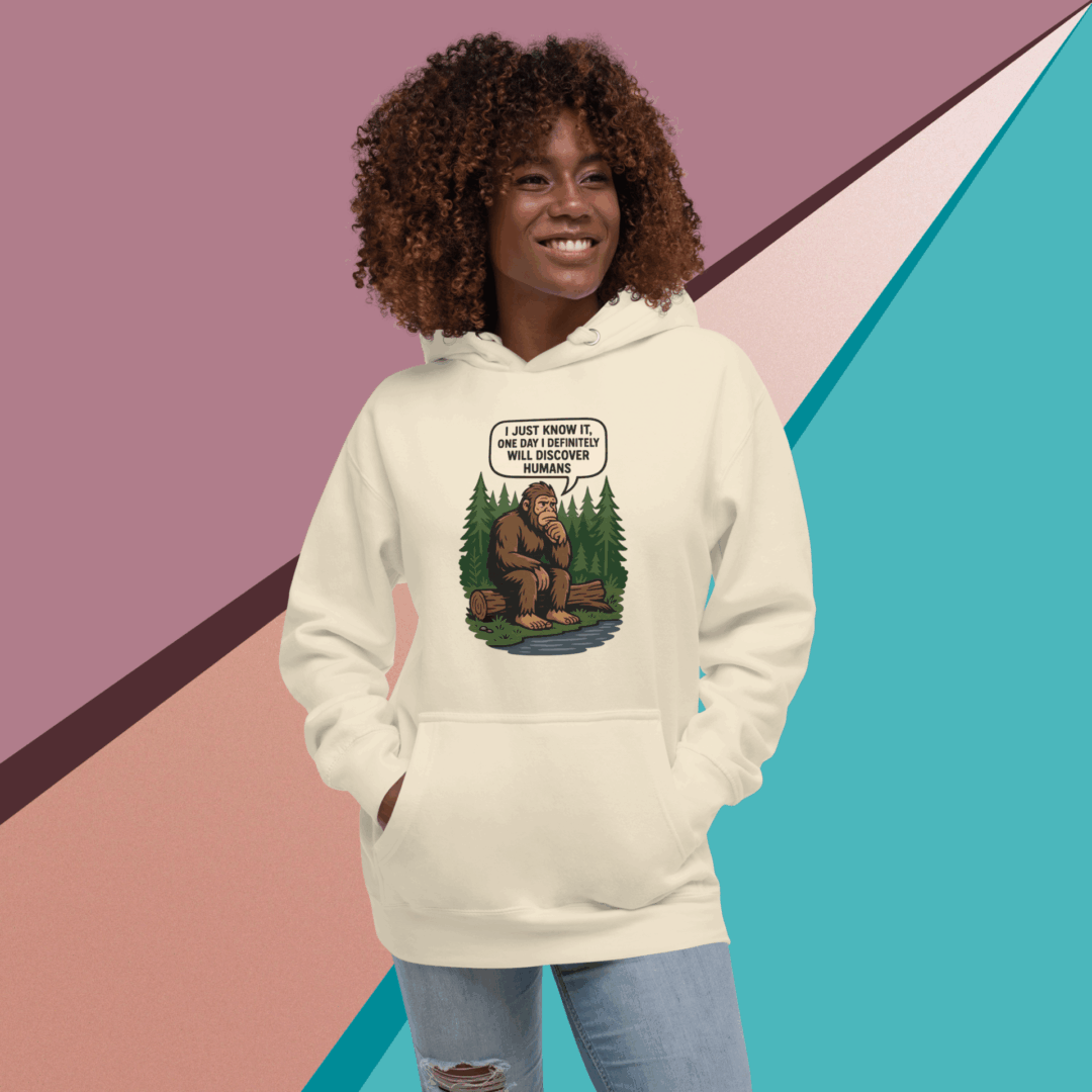 Smiling woman wearing a cream hoodie with a colorful graphic design.