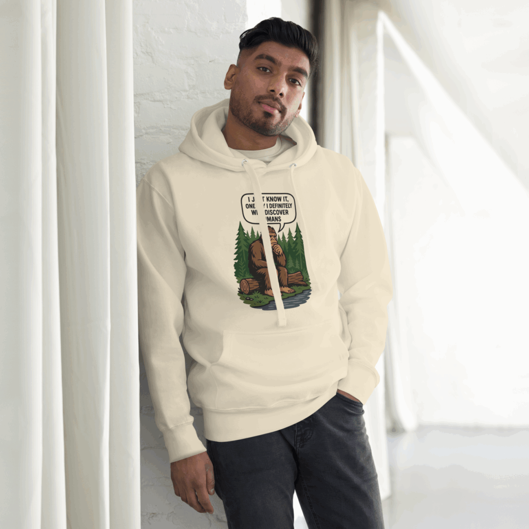 Man wearing a beige hoodie with a unique graphic design.
