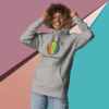cotton-heritage-m2580-i-unisex-premium-pullover-hoodie-carbon-grey-front-68e32543242bc Smiling person in a colorful hoodie against a geometric background.