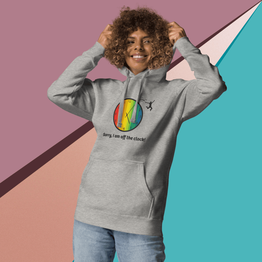 cotton-heritage-m2580-i-unisex-premium-pullover-hoodie-carbon-grey-front-68e32543242bc Smiling person in a colorful hoodie against a geometric background.