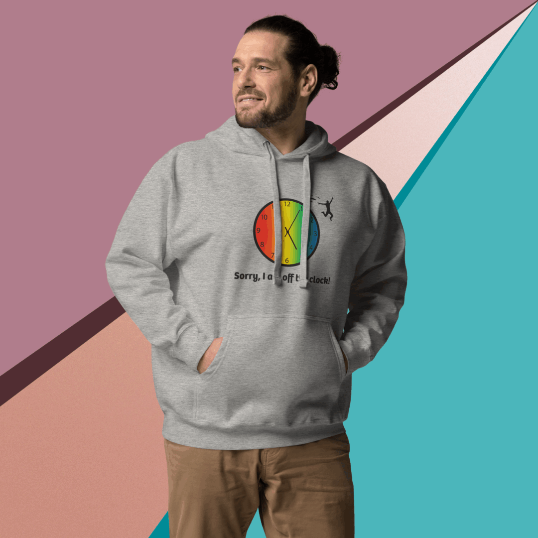 cotton-heritage-m2580-i-unisex-premium-pullover-hoodie-carbon-grey-front-68e326013e4fa Man wearing a gray hoodie with a colorful circular logo, standing against a geometric pastel background.