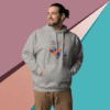 cotton-heritage-m2580-i-unisex-premium-pullover-hoodie-carbon-grey-front-68f0467299ecc Man wearing a gray hoodie with colorful graphics, standing against a geometric pastel background.