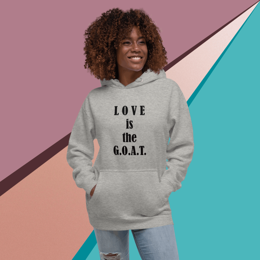 Smiling woman in a gray hoodie with "LOVE is the G.O.A.T." text.
