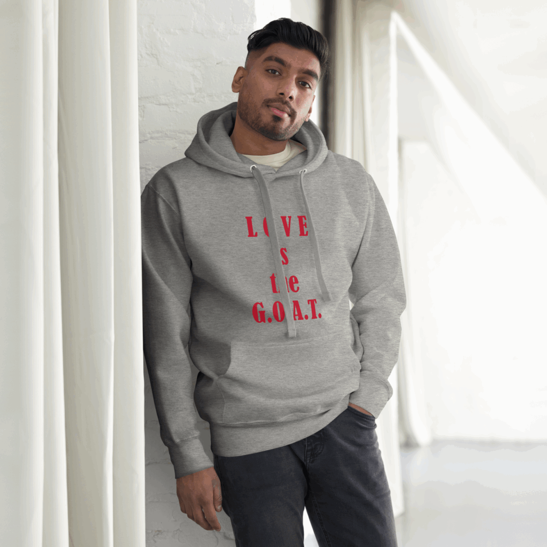 Man in gray hoodie with red text posing indoors.