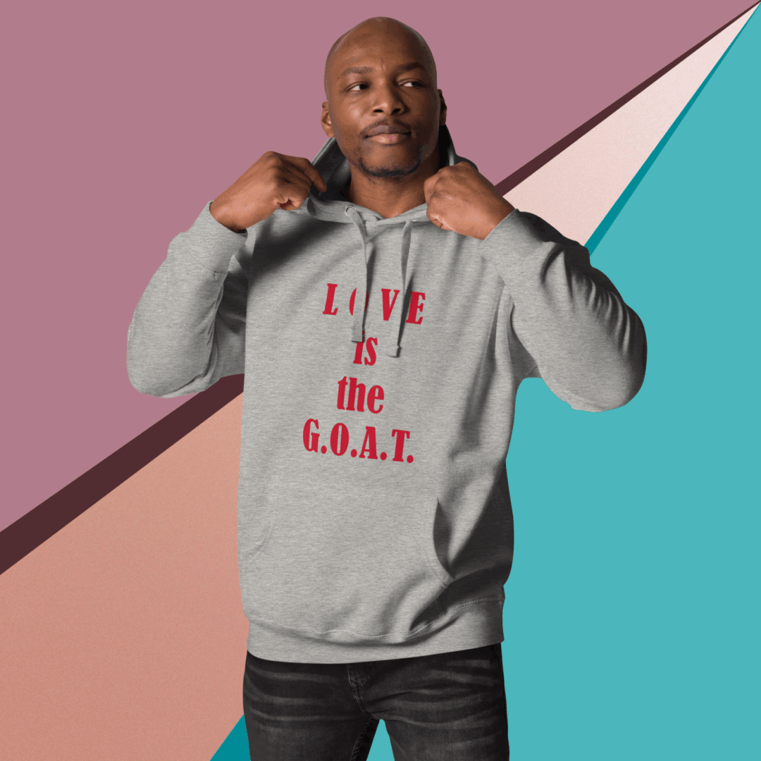 Man wearing a gray hoodie with red text "LIVE is the G.O.A.T.".