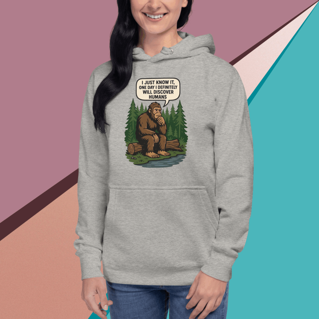 Woman wearing a gray hoodie with a Bigfoot design and text.