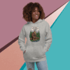 A smiling woman in a gray hoodie with a bear graphic stands against a colorful geometric background.