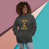 A woman wearing a hoodie saying 'LOVE is the G.O.A.T.' smiling.