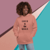 Smiling woman in a peach hoodie with 'LOVE is the G.O.A.T.' text.