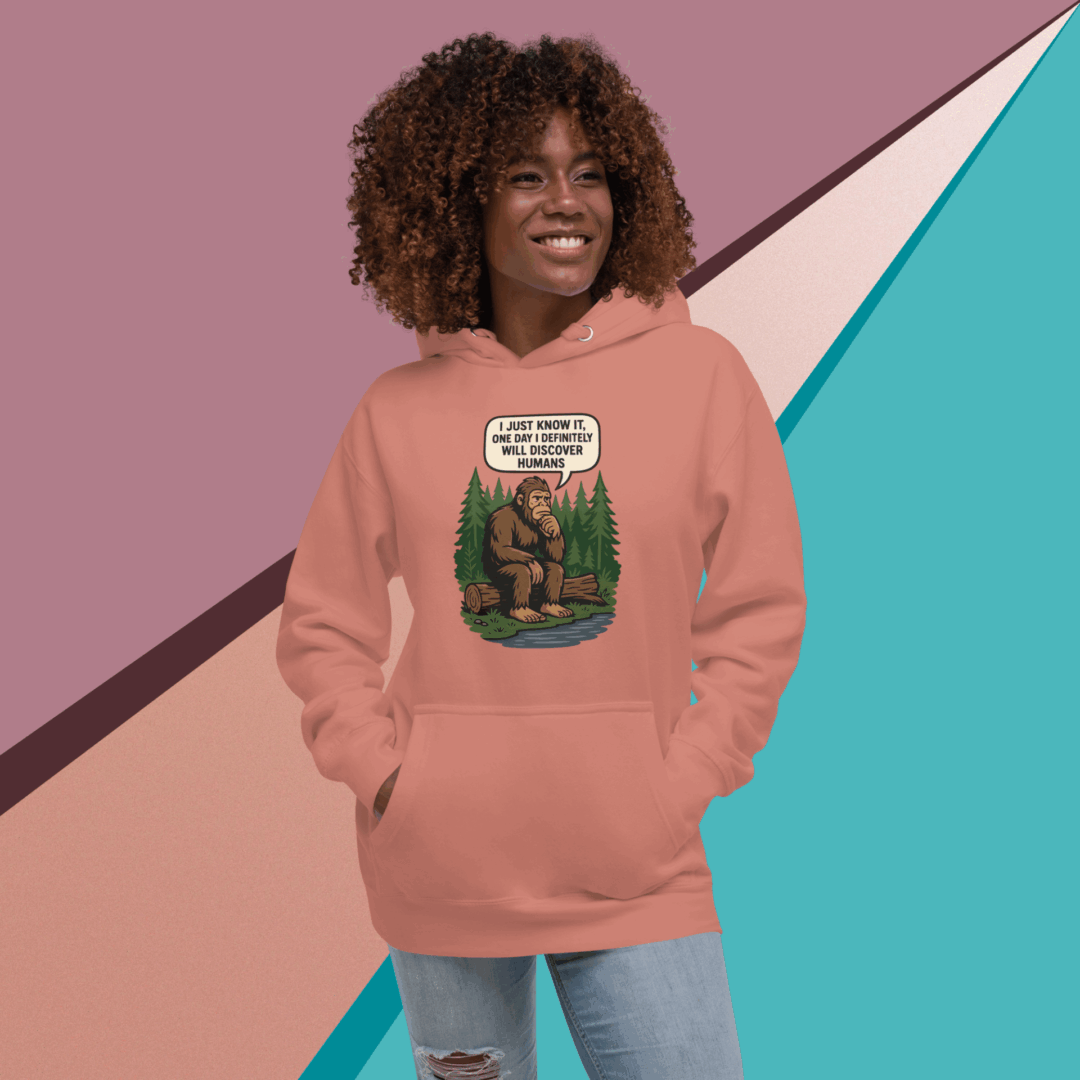 Smiling woman in a pink hoodie with a graphic design on the front.