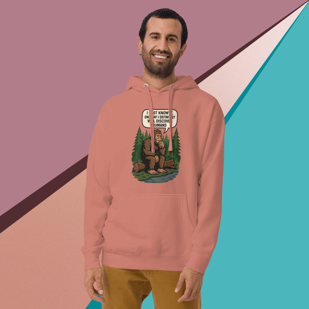Man wearing a dusty rose hoodie with a graphic design, smiling against a colorful geometric background.
