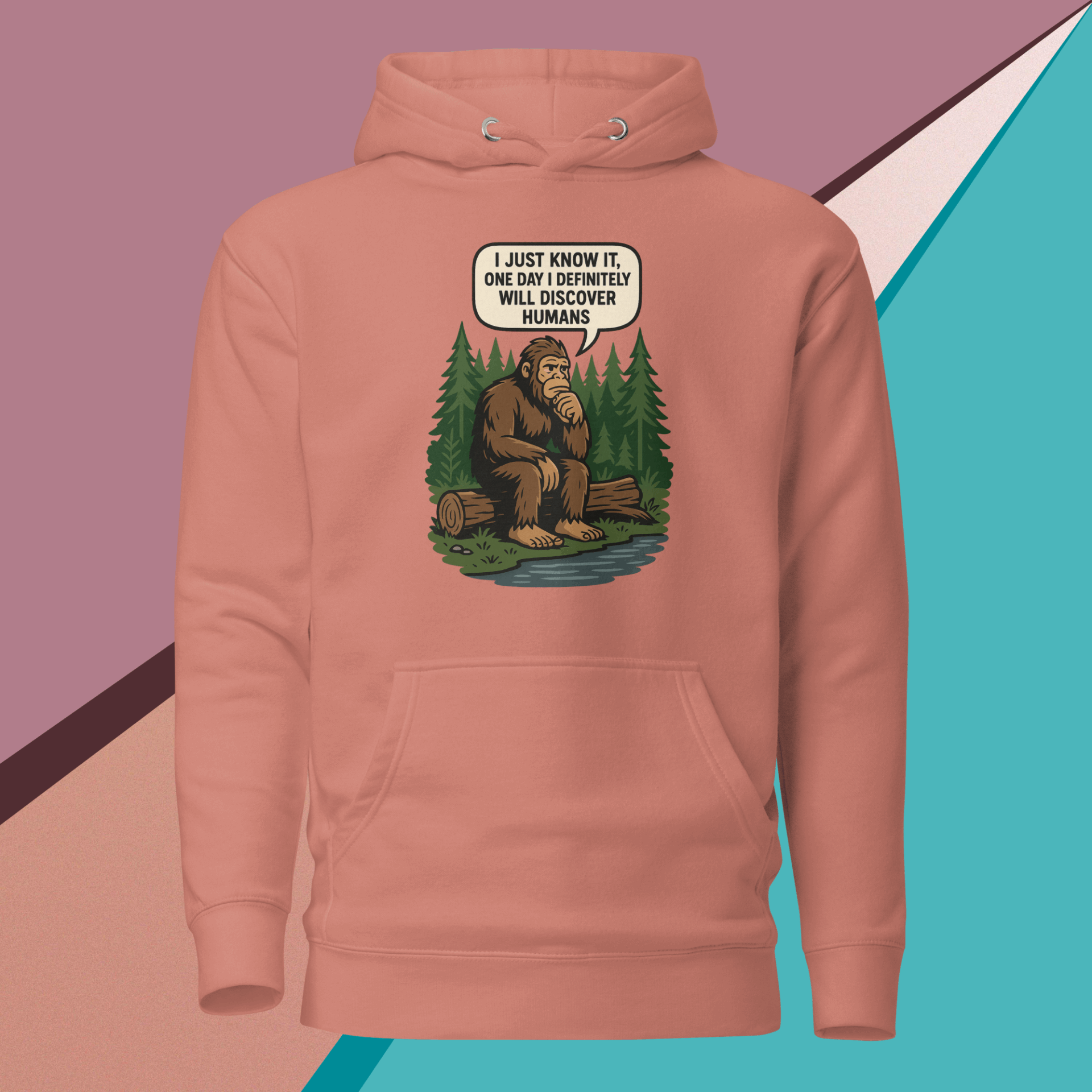 Pink hoodie with a thoughtful Bigfoot cartoon saying he'll discover humans one day.