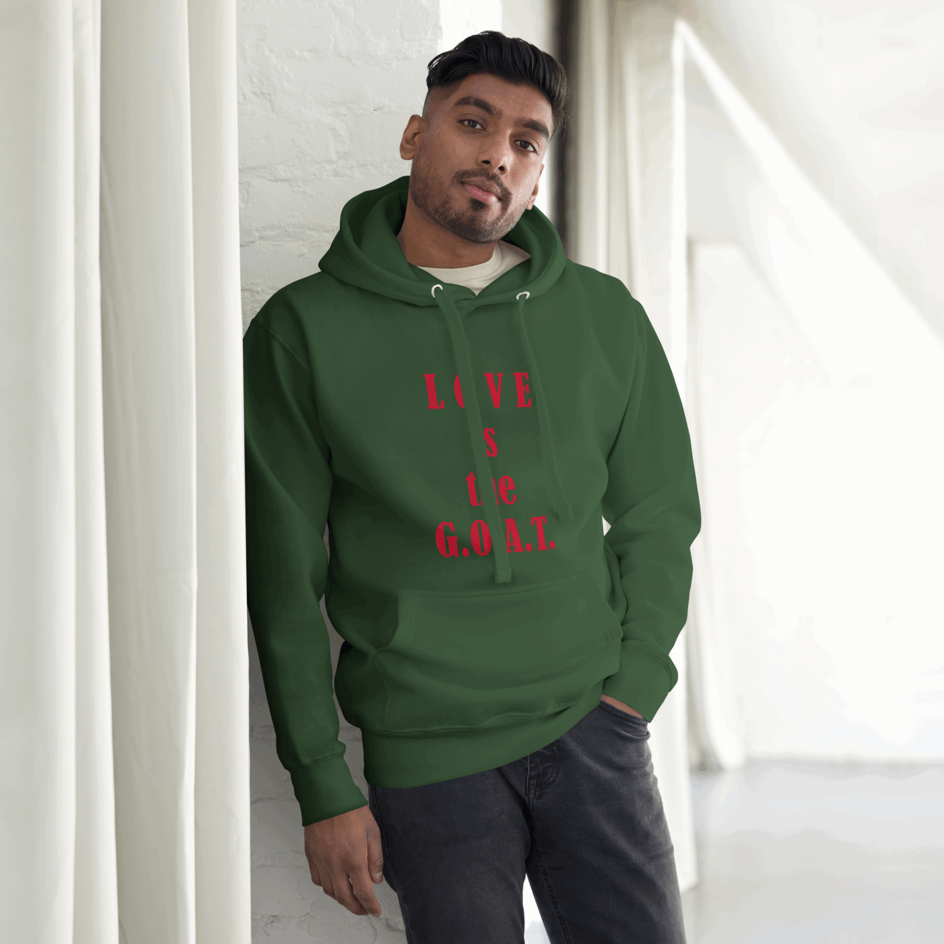 Man wearing green hoodie with red text, standing indoors.